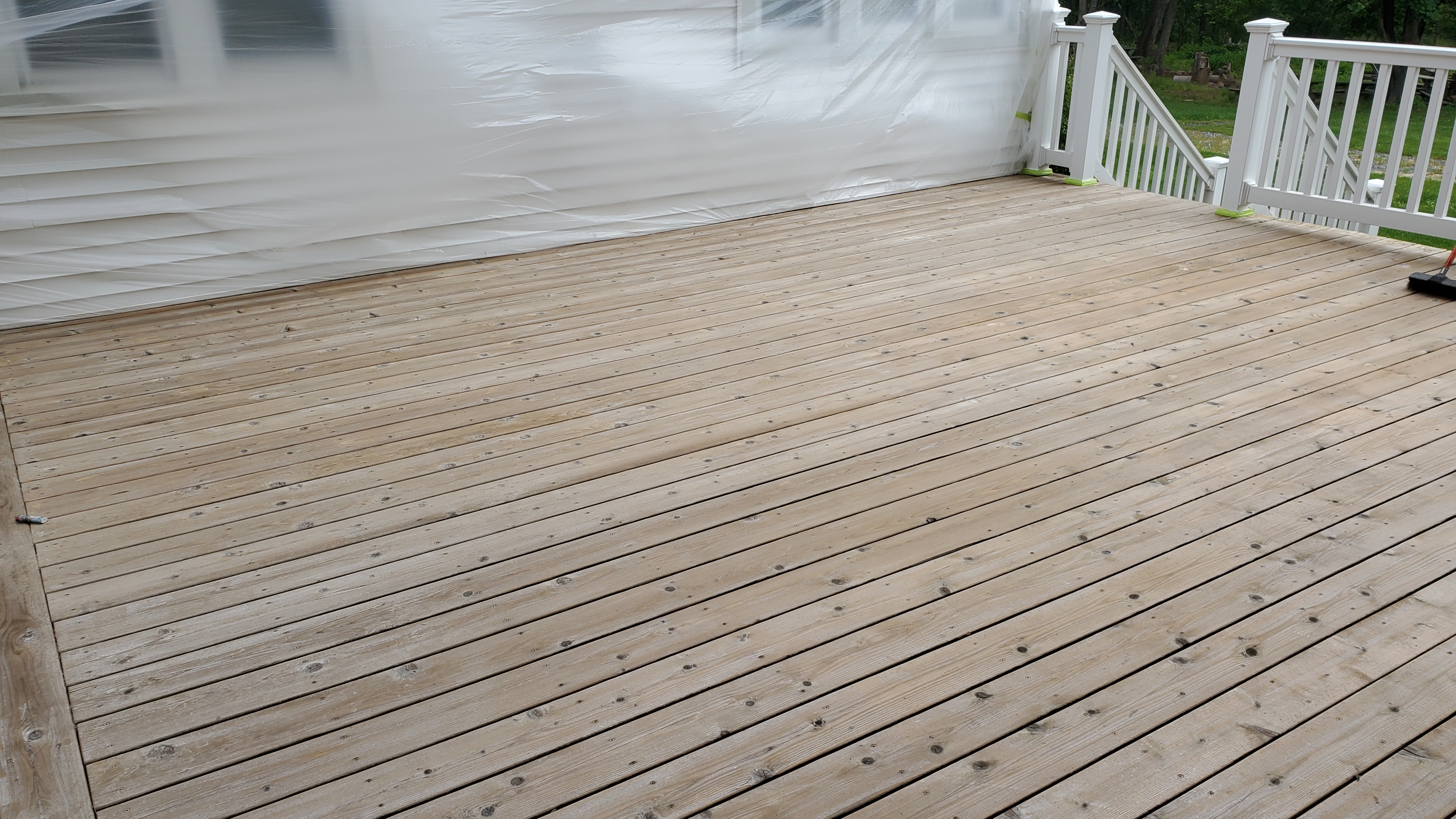 Same wood deck after professional pressure washing showing restored natural blonde wood color