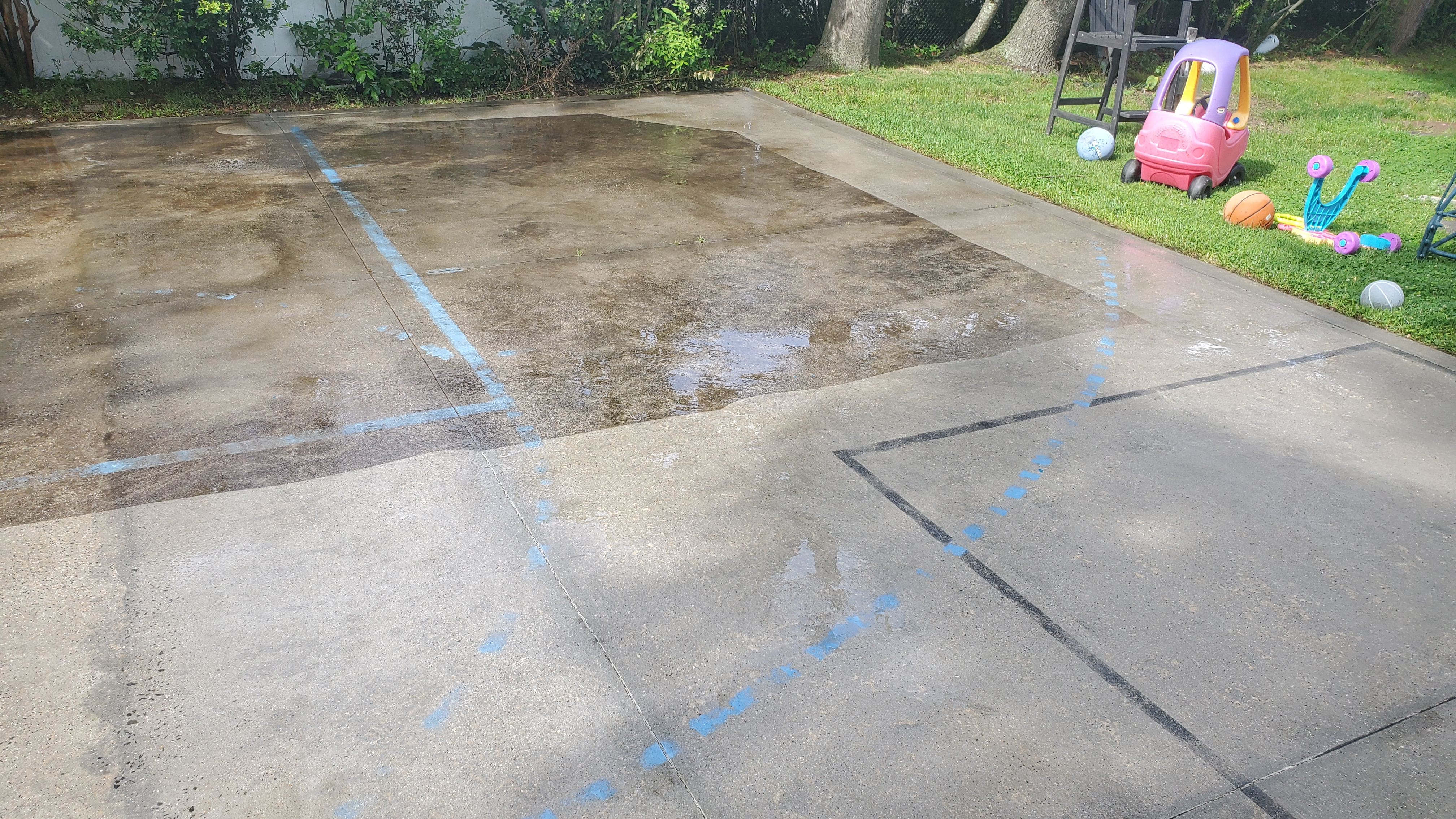 Concrete surface mid-clean showing dramatic contrast between dirty and freshly cleaned sections