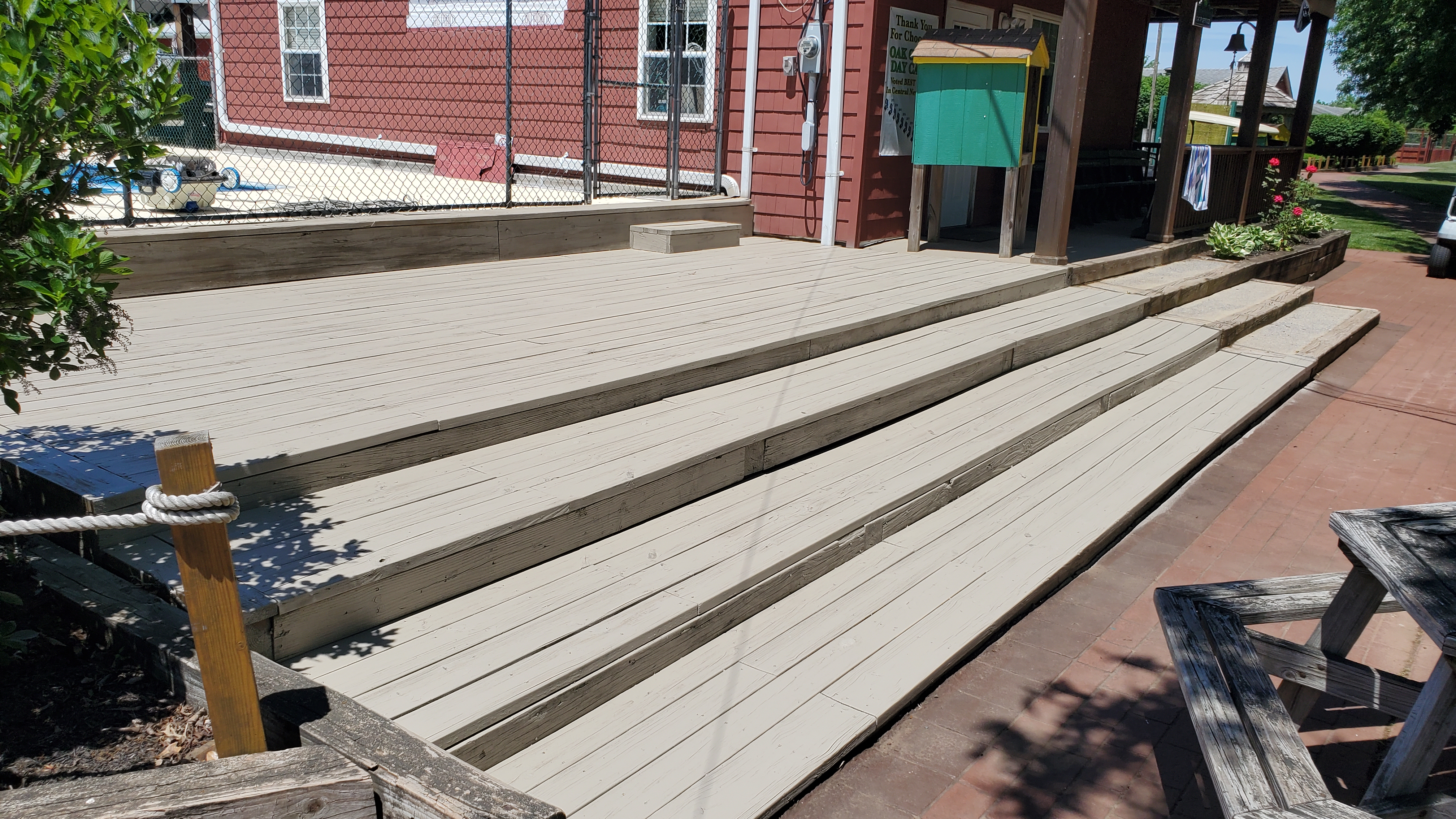 Commercial deck stained to a warm cedar tone showing full transformation after cleaning and staining