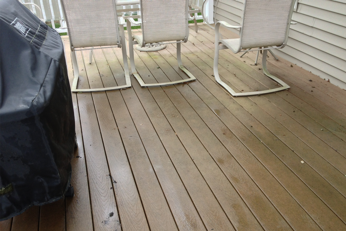 Composite Trex deck with algae staining and organic buildup before professional soft wash cleaning