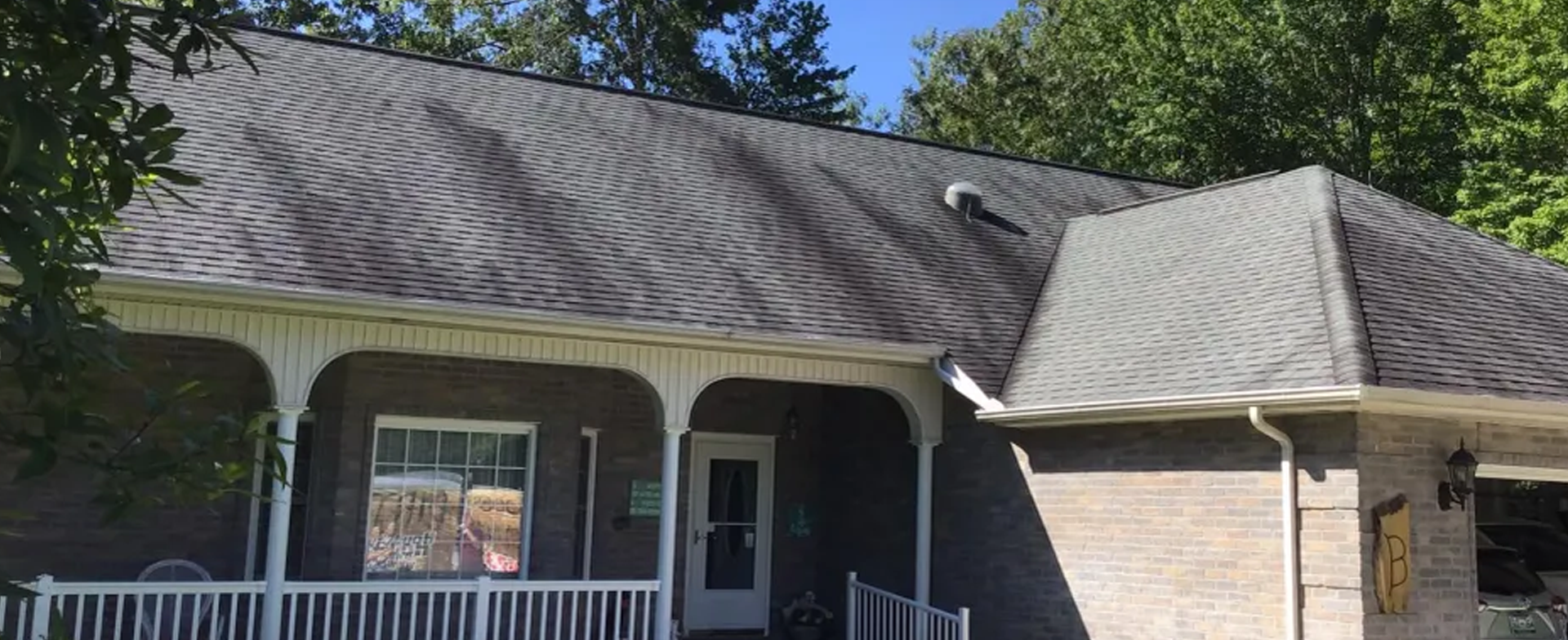 Ranch style brick home with heavily stained and streaked roof shingles