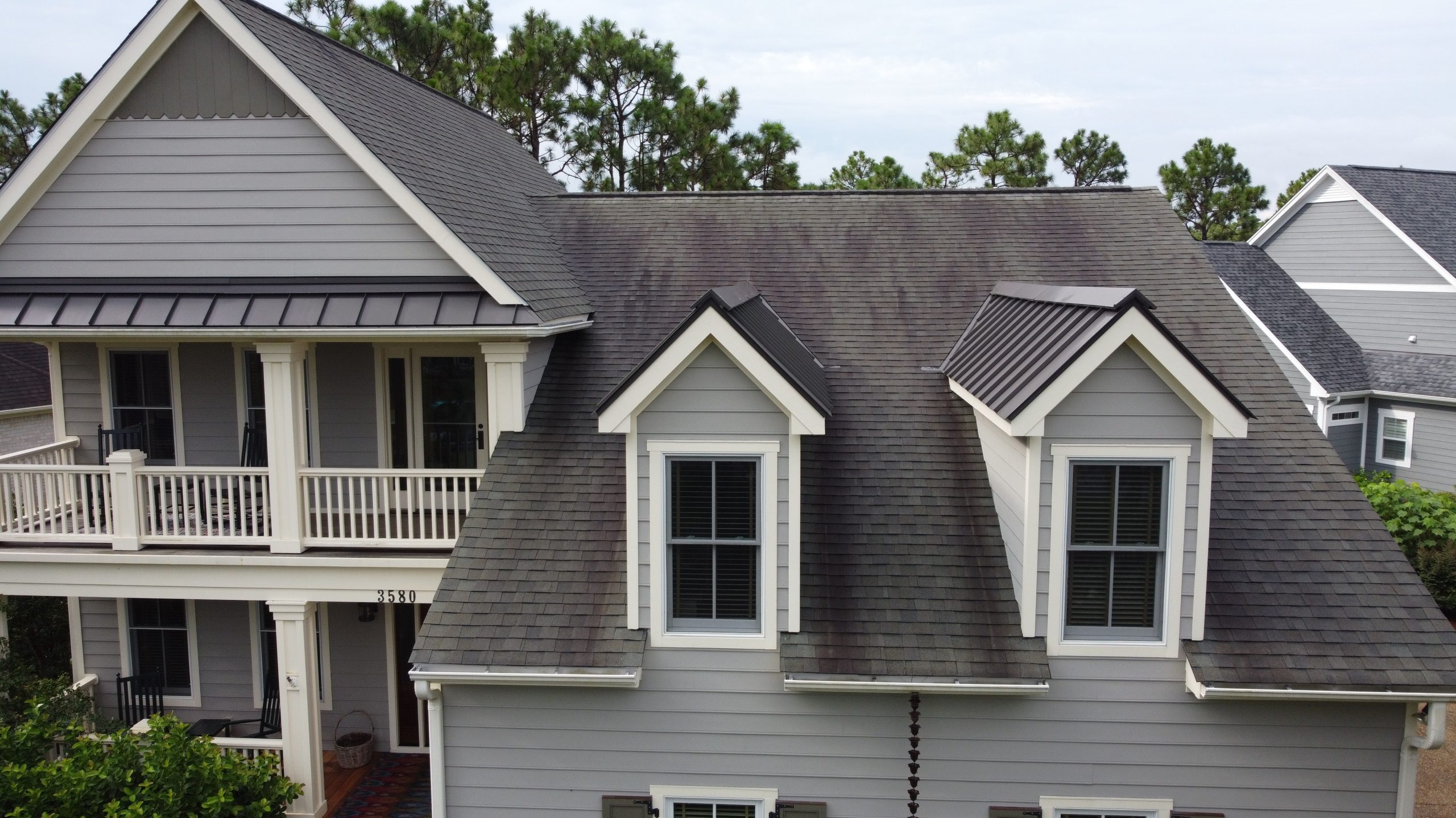 Aerial view of a Florida home with severe black algae streaks across the roof shingles before soft wash cleaning
